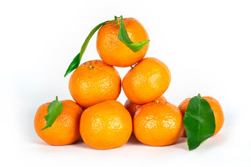 Delicious, beautiful tangerines with green leaves lie well over each other on a white background with a slight shadow