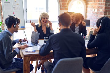 Group of call center workers smiling happy and confident. Working together with smile on face using headset at the office.