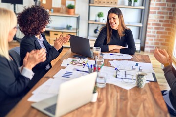 Group of business workers smiling happy and confident. Working together with smile on face applauding one of them at the office