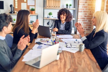 Group of business workers smiling happy and confident. Working together with smile on face applauding one of them at the office