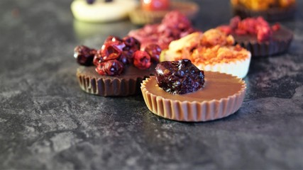 chocolate candies decorated with berries on a black background