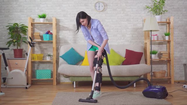 housewife after injury knee bend orthosis knee brace vacuums in the living room