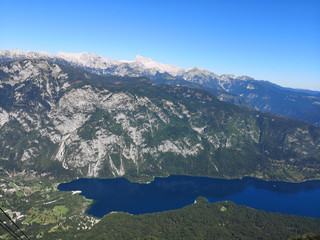A beautiful view from above of Lake Bohinj and the Bohinj valley with the mountains in the background