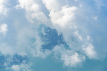 White fluffy clouds fly over the ocean and islands. Photo from the plane.
