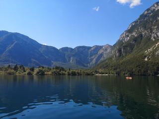 Fototapeta na wymiar Beautiful view of the crystal clear Bohinj lake from the water with the mountains in the background