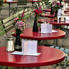 Empty tables of street cafe decorated with flowers