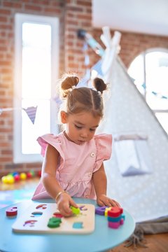 Young beautiful toddler learning mathematics playing with maths game at kindergaten