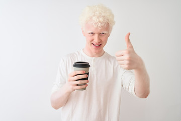 Young albino blond man drinking coffee standing over isolated white background happy with big smile doing ok sign, thumb up with fingers, excellent sign