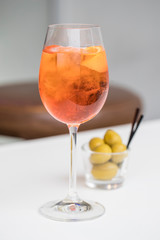 Spritz apero beverage and green olives served in a bar