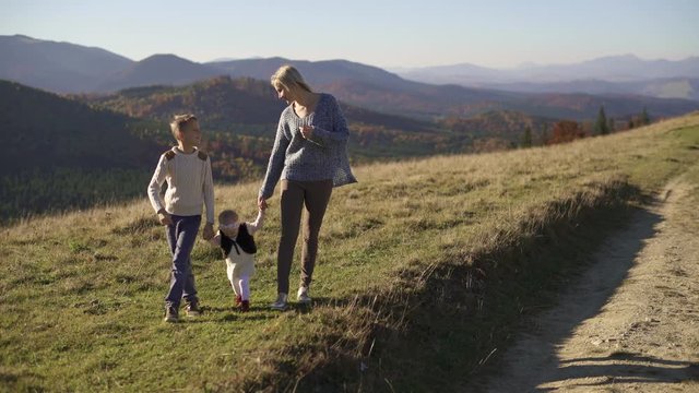Mom with two children walking on mountain trails