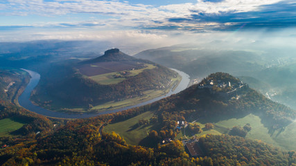 Konigstein Fortress - a Saxon mountain fortress near the town of Konigstein, located on a plateau rising  247 meters above the Elbe level, bathed in fog, aerial view