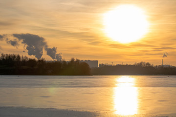 Winter sunset on the background of a frozen pond, lake. Moscow. Russia.