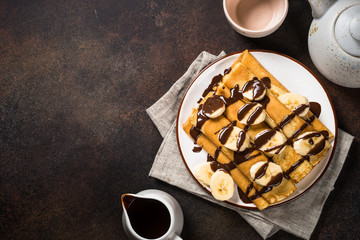 Crepes with chocolate and banana top view.