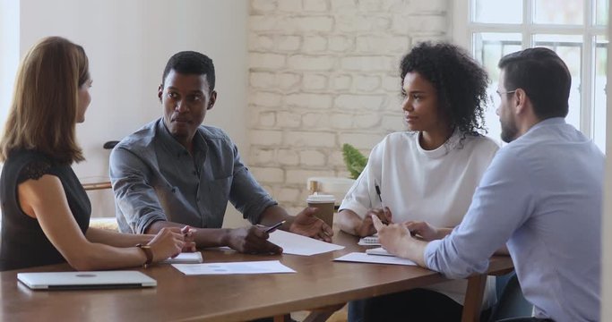Motivated group of multiracial company stuff discussing working issues.