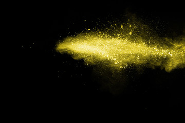 Yellow powder explosion on black background.