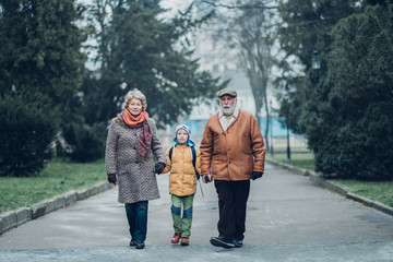 Grandparents with grandson enjoying time together in park.