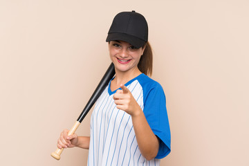 Young girl playing baseball over isolated background points finger at you with a confident expression