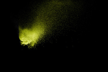 Fototapeta na wymiar Yellow powder explosion on black background.