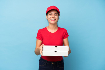 Young woman holding a pizza over isolated pink wall applauding