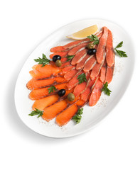 Assorted slices of salted red fish fillet with olives and herbs on a white plate