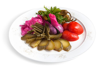 Pickled vegetables on a white plate. For salting, you need water with salt, vinegar and spices.