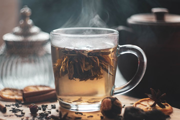 flower tea in a transparent mug with welding and spices/ vintage bottle and clay teapot