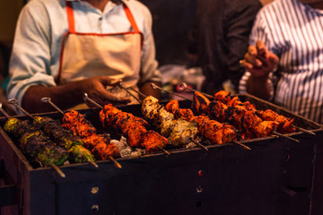 Street food/Traditional Grilled tandoori of  assorted meats with charcoal and fire on skewers