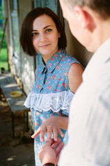 portrait of a girl in a summer sundress who looks affectionately at her boyfriend who takes her hand