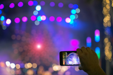 Fototapeta na wymiar Close up of recording video with smartphone during a concert. colorful crowd on concert, disco night. - Image
