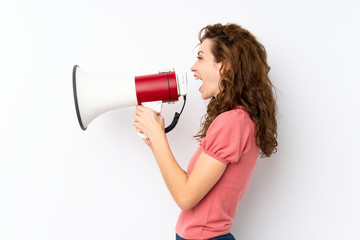 Young pretty woman over isolated background shouting through a megaphone