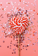 abstract background with a heart-shaped lollipop in the center of the frame and sparkles in the...