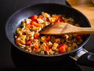 Champignon mushrooms  fried with meat, tomato and onion in pan