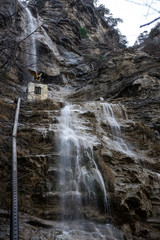 Waterfall in winter. Flowing jets of water along the mountain
