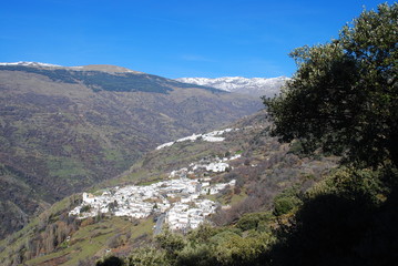 Fototapeta na wymiar View of a white village in Las Alpujarras, Granada, with snowed mountains.