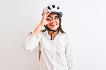 Beautiful businesswoman wearing glasses and bike helmet over isolated white background doing ok gesture with hand smiling, eye looking through fingers with happy face.