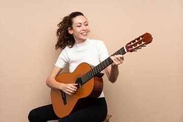 Fototapeta premium Young woman with guitar over isolated background