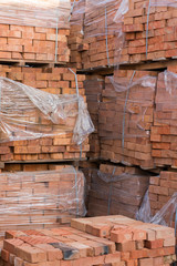 Several pallets with concrete brick stacked on top of each other in depot. Industrial production of bricks. vertical photo