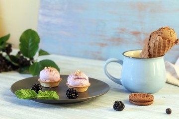 Chocolate ice cream in waffle cones, cookies, berries on a wooden table, sweet dessert 