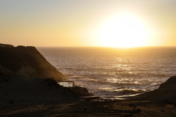 Obraz premium Distant People in Sunset on Oregon Coast