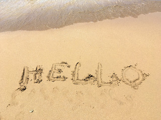 the inscription Hello on the sand by the sea