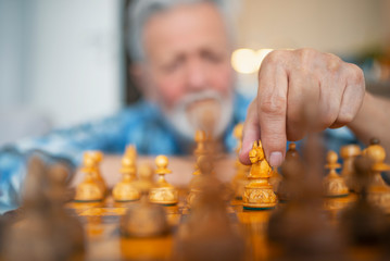 Playing wooden chess pieces. Close up of hands confident senior man playing chess game to development analysis new strategy plan, leader and teamwork concept for success.