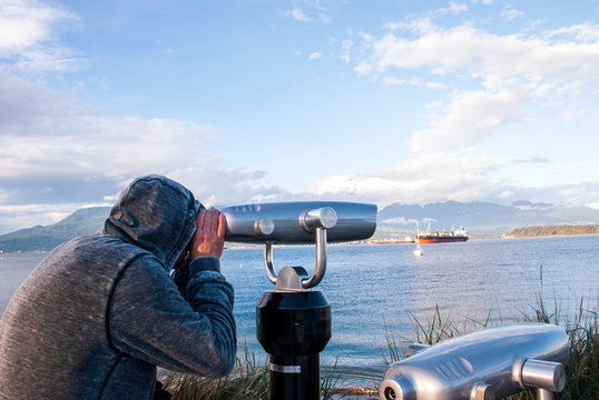 Man watching sights through the huge binoculars at Jericho viewpoint