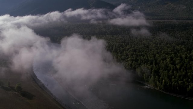 4K aerial view. Low flight over a fresh cold mountain river with green trees. 