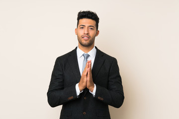 Young handsome businessman man over isolated background pleading