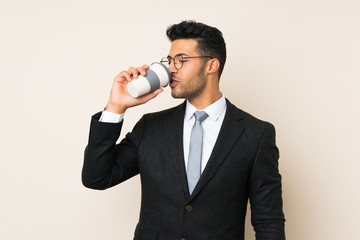 Young handsome businessman man holding coffee to take away over isolated background