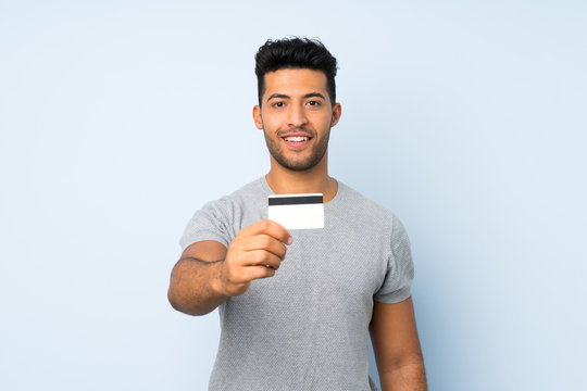 Young Handsome Man Over Isolated Background Holding A Credit Card