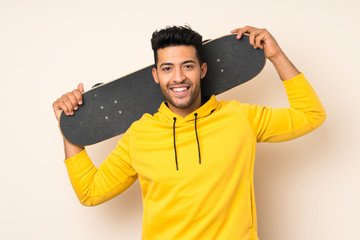 Young handsome man over isolated background with skate