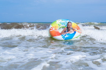 Obraz premium Girl on an inflatable circle in a raging sea, ocean.
