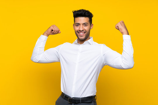 Young handsome man over isolated yellow background celebrating a victory