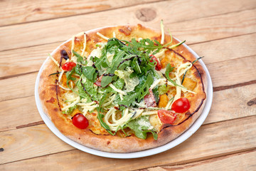 pizza with fresh vegetables on the wooden background